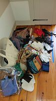 Overview of gloves, scarves, bags, wallets arranged on floor showing entire lot