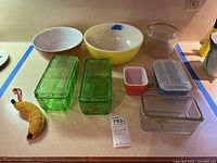Full overview of all items showing mixing bowls, green glass dishes, Pyrex dishes, and additional glass containers.