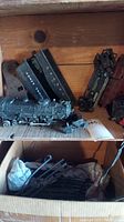Image showing Lionel model train engine, train cars, and box with track pieces inside wooden shelving unit.