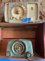 Shows both Zenith Y72A radio on top and blue-green Crosley radio below on shelf