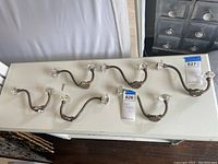 Set of six brass and crystal coat hooks laid out on a table, showing overall quantity and style.