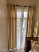 Curtain panels hanging on window, showing gold and sheer tea color curtains, capturing the drape and translucency