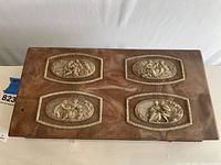 Top view of antique Italian marble jewelry box showing four pairs of detailed ivory-colored cameo reliefs depicting classical scenes.