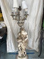 Full view of the torchiere floor lamp showing the plaster statue base and three light sockets with small lamp shades.