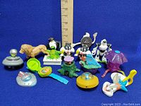 All vinyl figure toys including cartoon characters and accessories, ruler shown for size reference