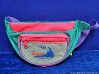 Front view of the Esso fanny pack showing Esso logo, red and gray zippered compartments, and purple strap.