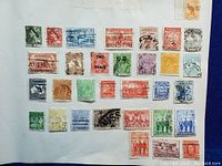 Full sheet of about 30 assorted vintage Australian stamps from 1930s-1940s affixed to paper backing.
