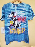 Full view of the tie-dye blue and white T-shirt with Sylvester and Tweety graphic and "What Attitude?" text.