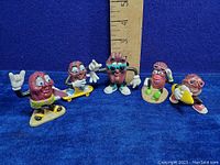 Full shot of the five California Raisins vinyl figures including their poses and size relative to a ruler