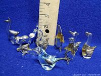 Photo showing 7 glass animal figurines with ruler for scale, highlighting sizes approximately up to 3.5 inches tall.