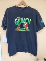 Front view of vintage black t-shirt with The Grinch and Max printed colorful graphic and "THE GRINCH" text.