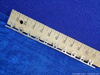 Photo showing the Volkswagen chrome emblem next to a ruler measuring approximately 11 inches in length.