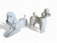 Photo showing both Beswick and Paragon white poodle figurines from the front and side angles, highlighting their sculpted details and glossy finish.