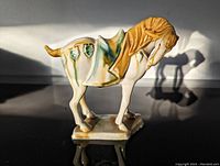 Side view of ceramic horse figurine showing sancai glaze colors and shape