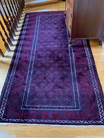 Full view of the wool area rug showing overall pattern, color, and size relative to furniture and floor.