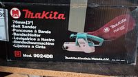Makita branded cardboard box with model 9924DB and 3" belt sander illustration