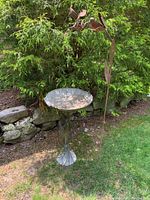 Overall view showing bird bath and hummingbird stake side by side in lawn setting