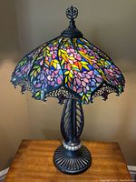 Full front view of Tiffany-style lamp on wooden table, unlit