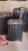 Three black Samsonite hardside suitcases grouped together
