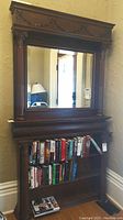 Front view of the two-piece set showing mirror over bookshelf with books (contents not included)