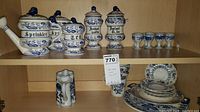 Blue and white ceramic canisters labeled Sprinkler, Tea, and Instant Coffee, six matching egg cups on the same shelf.