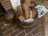 Both cauldrons side by side on brick hearth, large filled with kindling