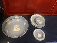 Wide shot of five Wedgwood wall plates arranged to show the design details and relative sizes