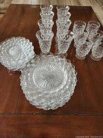 Stacked plates and multiple glasses showcasing the hobnail textured clear glass pattern.