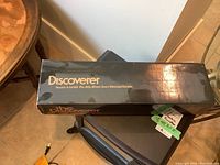 Closed box of Bausch & Lomb Discoverer 15-60x60 telescope with model info on top.