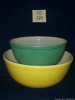 Photo of stacked green and yellow vintage Pyrex mixing bowls showing color and size difference.