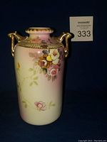 Front and side view of Nippon antique vase showing floral decoration and gold handles.