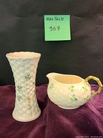Photo of the white porcelain Colleen Basketweave vase with dark green shamrocks and basketweave shamrock creamer on a purple fabric backdrop.
