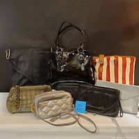 Photo of all six handbags together showing mix of styles, colors, and materials including patent leather, canvas, and quilted designs.