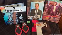Photo showing Pearl Jam flip flops, Experience Music Project book 'Crossroads', Time magazine with Pearl Jam cover, Billy Joel and Huey Lewis & the News tour programs grouped together.