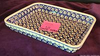 Side angle of rectangular casserole dish showing blue circular pattern inside and out.