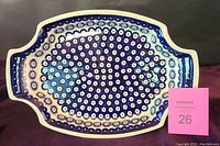 Top down view of the blue and cream patterned ceramic serving dish on dark background.