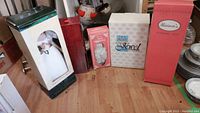 Lot of five boxed porcelain collector dolls displayed on floor