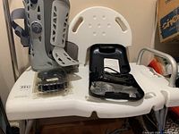 Walking brace boot, bathing chair, grooming kit on white chair surface