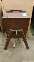 Front view of the antique wood washing tub showing the closed lid, handle and front legs.