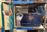 Photo of Angora Harbor 52" Ceiling Fan box and Field Sketch Easel box on a shelf.