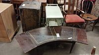 Curved wood coffee table with three panels, dark finish, decorative inlay, and scratches visible on surface