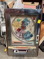 Full front view of mechanical pinball machine showing wooden and chrome frame, glass front, playfield layout.