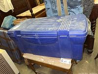 Closed blue plastic tote container storing clothing items