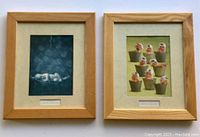 Pair of framed Anne Geddes prints side by side showing wood frames and artwork