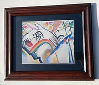Photo of framed Kandinsky abstract decorative print showing the wood frame and matted print inside.