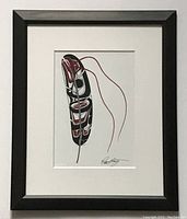 Framed Indigenous art print showing full view, black frame, white mat, glass panel, eagle feather design in black, red and white, with artist signature bottom right.