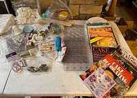 Overview of assorted cake decorating tools, candy molds, and cake decorating magazines arranged on a table.