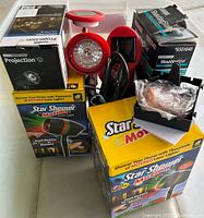 Laser lights and projectors with original packaging showing Star Shower Motion and Shooting Star models.