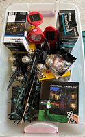 Photo showing a red solar spotlight, boxed string light sets, green string lights with metallic balls, and a boxed Christmas stage laser light with remote.
