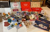 Full spread showing Paper Pumpkin kits boxes, rubber stamps, ink pads, embossing powders, pastel chalks, punches, and embellishments arranged on table